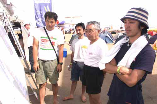 掲示板に見入るチームスガワラのクルー。